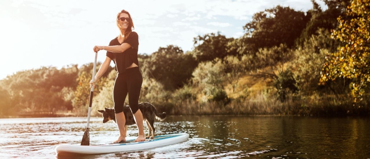 woman and dog paddleboarding on texas lake near wildcat ranch