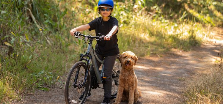 a kid on his bike with a dog on a Crandall hiking trail