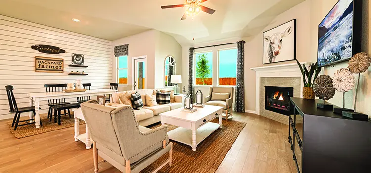 Bright living room with fireplace, farmhouse décor, and large windows.