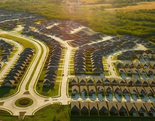 Aerial view of a large residential community surrounded by open green spaces.