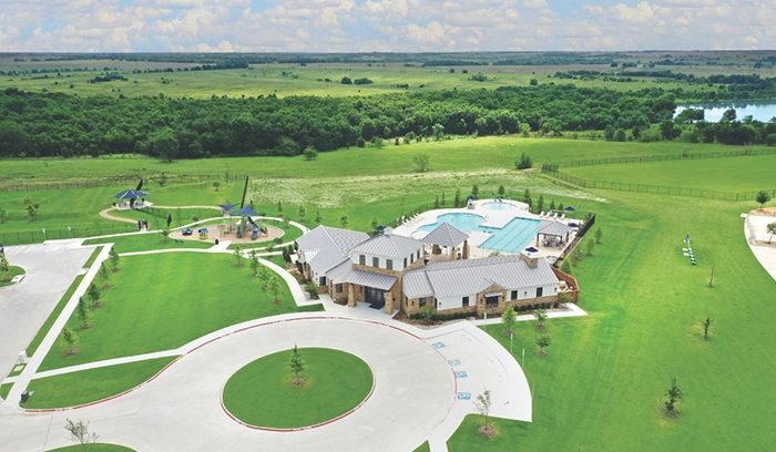 Aerial view of the Wildcat Ranch amenity center with pool, open green space, and surrounding landscape.